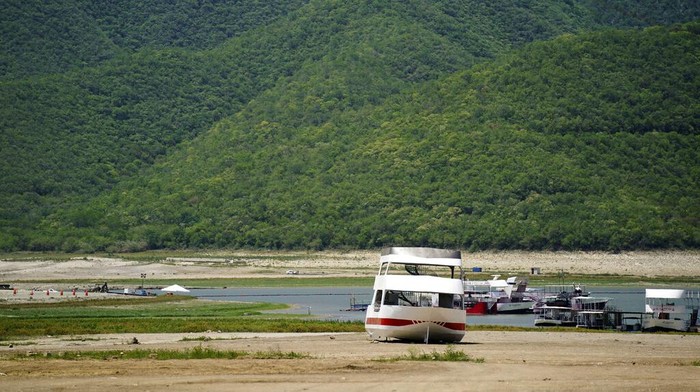 Potret Meksiko Dilanda Kekeringan Hebat Dry, cracked land and boats is visible in The Boca reservoir that supplies water to the northern city of Monterrey is almost dry as the northern part of Mexico is affected by an intense drought, in Santiago, Mexico, Saturday, July 9, 2022. Local authorities began restricting water supplies in March, as a combination of an intense drought, poor planning and high use has left the three dams that help supply the city dried up, with thousands of homes not receiving any water for weeks. (AP Photo/Fernando Llano)