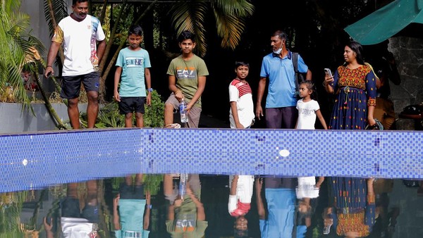 Sejumlah orang berada di pinggir kolam renang di rumah Presiden Sri Lanka.