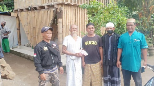 Salah satu tokoh adat Jro Mangku di Banjar Angantiga menerima daging kurban dari umat muslim di Hari Raya Idul Adha Minggu (10/7/2022)