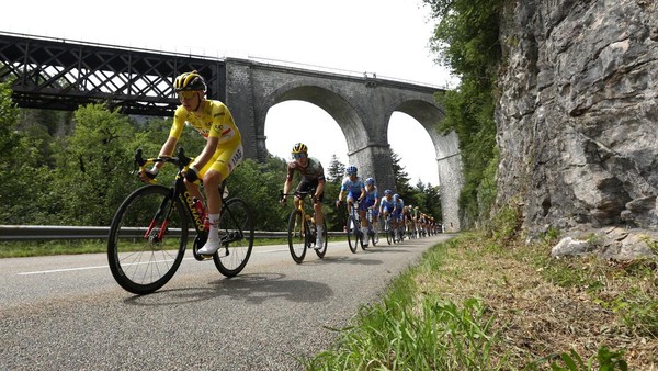 Pebalap Tadej Pogacar melintas di bangunan tua pada etape 9. Tour de France 2022 baru menyelesaikan 9 dari 21 etape pada Minggu (10/7). (Gonzalo Fuentes/Reuters)  