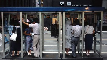 Orang-orang berkomunikasi di telepon umum, belum ada ponsel. Foto: Vintag.es