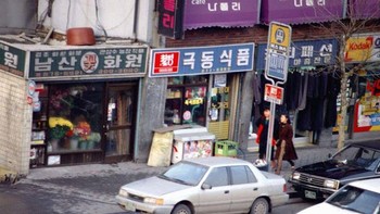 Suasana Seoul tahun 1980-an dalam rekaman fotografi. Banyak mobil lalu lalang dan orang berjalan di trotoar yang luas. Foto: Vintag.es