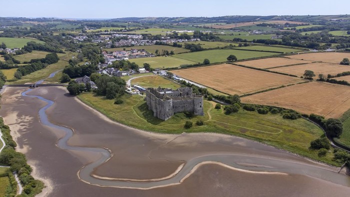 1241840061 PEMBROKESHIRE, WALES - JULY 12: An aerial view during low tide in the Carew River which runs alongside Carew Castle on July 11, 2022 in Pembrokeshire, Wales. Forecasters are predicting that it could be the hottest day of the year so far with highs of 30Β°C. The Met Office have issued an amber weather warning for heat on July 17. (Photo by Matthew Horwood/Getty Images)