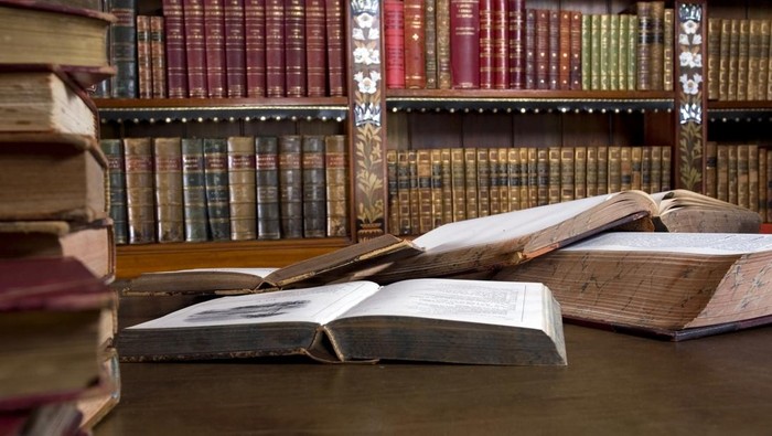 Mess on the desk. Open vintege books everywhere
