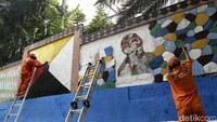 Sejumlah petugas PPSU mempercantik tembok di Jalan Kesejahteraan, Mangga Besar, Jakarta, Selasa (12/07/2022).