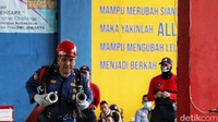 Petugas dengan sigap membawa selang pemadam kebakaran untuk meraih kemenangan.