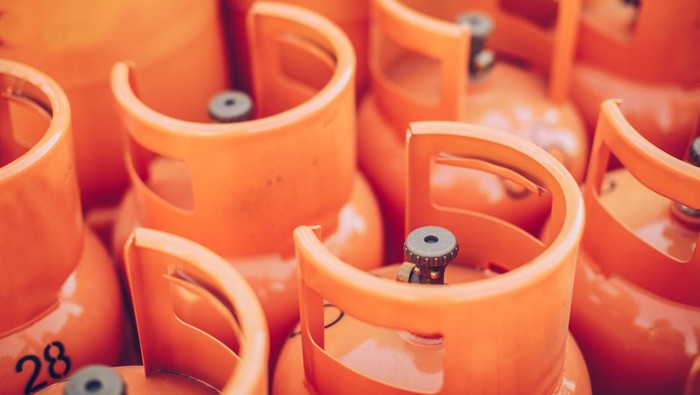Closeup mans hand operating valve of LPG cylinder for cooking