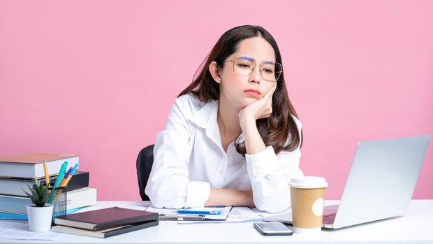 Young Asian women are tired from office work. Isolated Pastel Pink Background.