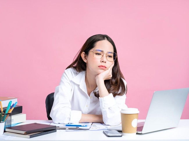 Young Asian women are tired from office work. Isolated Pastel Pink Background.
