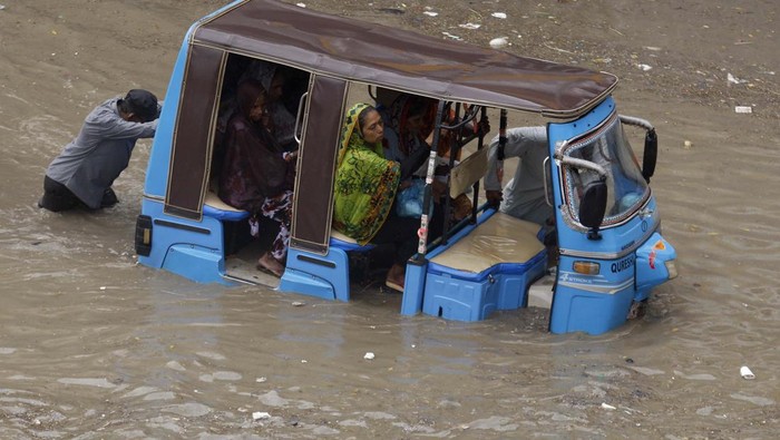 Karachi Terendam, Mobil Motor 'Berenang' A rickshaw driver and a volunteer push a rickshaw stuck in a flooded road after a heavy rainfall in Karachi, Pakistan, Monday, July 11, 2022. The death toll from rain-related incidents over the past month has risen to 147 as monsoon rains continue to lash Pakistan, triggering flash floods in some parts of the country, officials said. (AP Photo/Fareed Khan)