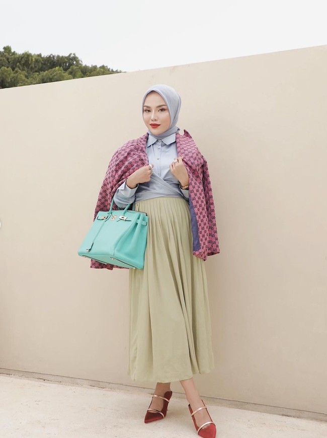 Tampil stylish, Medina Zein tampak memadukan tas hermesnya itu dengan outfit yang jugaa berwarna terang. Ia mengenakan hijab dan kemeja berwarna abu-abu muda, rok panjang berwarna hijau kekuningan, dan blazer merah muda. Penampilaannya itu dilengkapi dengan heels berwarna merah. Foto: Instagram/@medinazein
