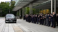 Mobil jenazah yang membawa jenazah mantan PM Shinzo Abe, melakukan kunjungan singkat ke Kantor Perdana Menteri. (AP/Eugene Hoshiko)