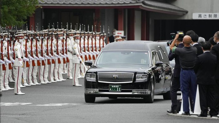 Momen Jenazah Shinzo Abe Tinggalkan Kuil untuk Dikremasi The hearse carrying the body of former Japanese Prime Minister Shinzo Abe moves through between an honor guard and attendants as it leaves Zojoji temple after his funeral in Tokyo on Tuesday, July 12, 2022. Abe was assassinated Friday while campaigning in Nara, western Japan. (AP Photo/Hiro Komae)