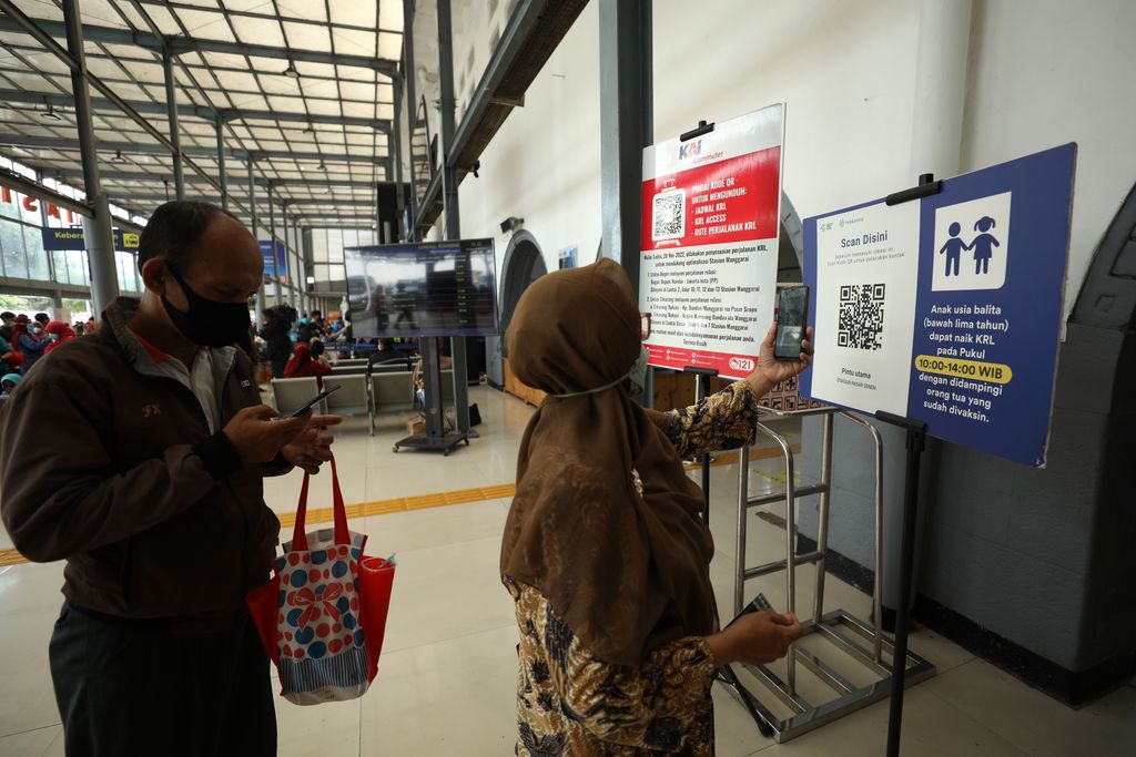 Sejumlah penumpang kereta KRL melakukan scan PeduliLindungi di Stasiun Pasar Senen, Jakarta, Selasa (12/7/2022). Pemerintah telah menerbitkan aturan perjalanan terbaru merespons kenaikan kasus COVID-19. Aturan-aturan perjalanan terbaru bakal mulai berlaku mulai 17 Juli 2022 mendatang. (CNBC Indonesia/Tri Susilo)