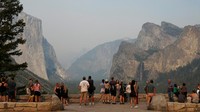 Turis melihat ngarai Yosemite yang diselimuti asap kebakaran hutan.