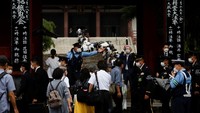 Petugas tampak mengatur para pelayat agar tidak menumpuk di dalam kuil.