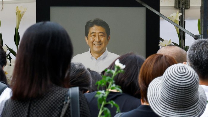 People gather to offer flowers at Zojoji Temple, where the funeral of late former Japanese Prime Minister Shinzo Abe, who was shot while campaigning for a parliamentary election, will be held, in Tokyo, Japan July 12, 2022. REUTERS/Kim Kyung-Hoon