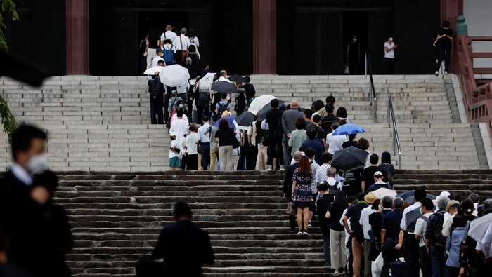 People gather to offer flowers at Zojoji Temple, where the funeral of late former Japanese Prime Minister Shinzo Abe, who was shot while campaigning for a parliamentary election, will be held, in Tokyo, Japan July 12, 2022. REUTERS/Kim Kyung-Hoon