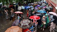 Orang-orang menunggu di luar pusat distribusi bantuan makanan.