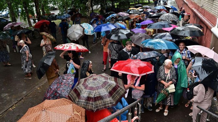 Warga Ukraina Hujan-hujanan Demi Bantuan Makanan Volunteers help to bring food rations to a food aid distribution center, managed by different NGOs and called