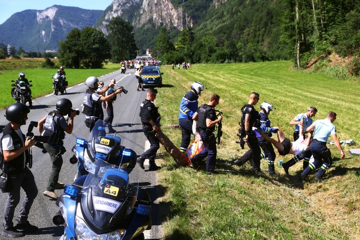 1241857527 UAE Team Emirates team's Slovenian rider Tadej Pogacar (C) wearing the overall leader's yellow jersey and the pack of riders are temporarily immobilized by race regulators due to a demonstration by environmental protestors on the race route during the 10th stage of the 109th edition of the Tour de France cycling race, 148,1 km between Morzine and Megeve, in the French Alps, on July 12, 2022. (Photo by Marco BERTORELLO / AFP) (Photo by MARCO BERTORELLO/AFP via Getty Images)