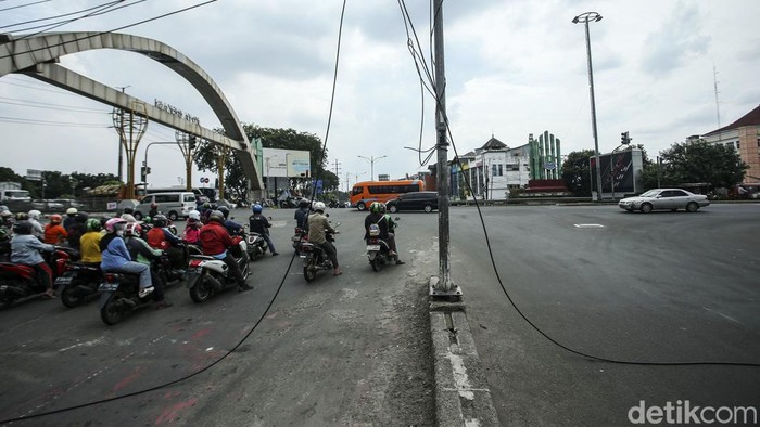 Sejumlah kendaraan melintas di jalan Cempaka Margahayu, Bekasi Timur, Rabu (13/7/2022). Kabel yang putus itu nampak melintang di jalan.