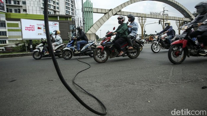 Sejumlah kendaraan melintas di jalan Cempaka Margahayu, Bekasi Timur, Rabu (13/7/2022). Kabel yang putus itu nampak melintang di jalan.