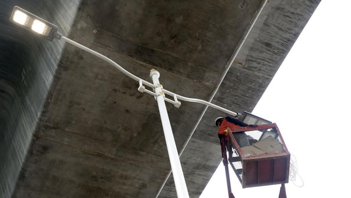 Begini Proses Perbaikan Lampu di Kolong Tol Layang Bekasi Raya Petugas melakukan perawatan lampu jalan yang berada di bawah Tol Layang Bekasi Raya. Perawatan itu meliputi perbaikan jaringan dan penggantian lampu yang mati.