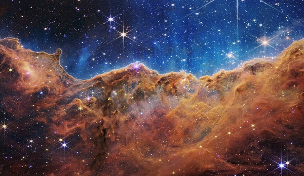 Nebula Carina, awan debu dan gas tempat lahirnya bintang dengan sangat detail sehingga gambarnya hampir terlihat tiga dimensi. Disebut Tebing Kosmik yang tampak seperti pegunungan terjal pada malam hari yang diterangi cahaya bulan. Padahal kenyataannya, itu adalah tepi rongga gas raksasa di dalam NGC 3324, dan puncak tertinggi dalam gambar ini tingginya sekitar 7 tahun cahaya. (dok NASA)