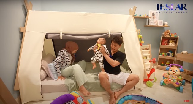 Tempat tidur di kamar baby Leslar juga dibuat unik menyerupai seperti layaknya sebuah tenda. Lesti dan Billar bahkan sampai tertarik untuk mencoba tempat tidur anaknya itu. Foto: YouTube/Leslar Entertainment