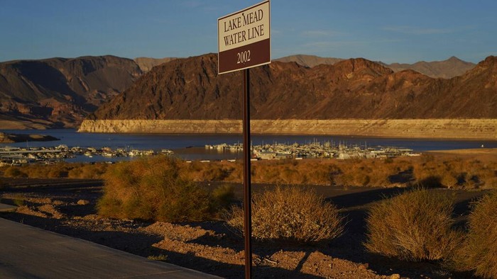 A sign marks the water line from 2002 near Lake Mead at the Lake Mead National Recreation Area, Saturday, July 9, 2022, near Boulder City, Nev. The largest U.S. reservoir has shrunken to a record low amid a punishing drought and the demands of 40 million people in seven states who are sucking the Colorado River dry. (AP Photo/John Locher)