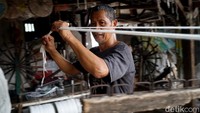 Di tengah gempuran teknologi canggih, Supandi masih setia memintal benang secara manual atau tradisional.
