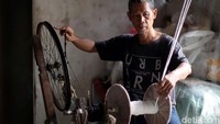 Supandi (54) tengah memintal benang secara tradisional di Jakarta, Rabu (13/7/2022).