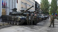 Tampak prajurit Republik Rakyat Luhansk berfoto dengan latar sejumlah tank pasukan Ukraina yang dipamerkan di kawasan Lisichansk.