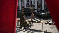  Seorang warga setempat berbicara dengan prajurit Rusia di tengah pameran tank dan senjata yang diamankan dari pasukan Ukraina di Lisichansk, Selasa (12/7/2022).