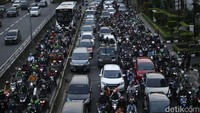 Pengendara sepeda motor terpaksa menerobos jalur TransJakarta untuk menghindari macet.