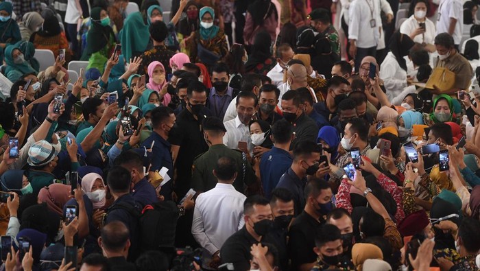PREDISEN BERIKAN NIB KEPADA PELAKU USAHA MIKRO Presiden Joko Widodo (tengah) melayani ajakan berswafoto warga usai acara pemberian Nomor Induk Berusaha (NIB) pelaku Usaha Mikro Kecil (UMK) perseorangan tahun 2022 di Jakarta, Rabu (13/7/2022). Presiden Joko Widodo memberikan Nomor Induk Berusaha (NIB) ke 2.500 pelaku UMK dari Provinsi DKI Jakarta dan sekitarnya. ANTARA FOTO/Akbar Nugroho Gumay/rwa.