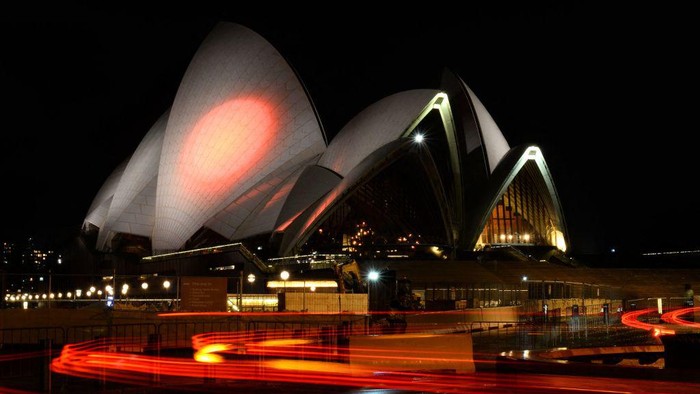 Ragam Cara Beri Penghormatan Terakhir untuk Shinzo Abe Australia's landmark Opera House in Sydney is lit up in the colours of Japan on July 10, 2022, in honour of slain former Japanese prime minister Shinzo Abe. (Photo by Muhammad FAROOQ / AFP) (Photo by MUHAMMAD FAROOQ/AFP via Getty Images)