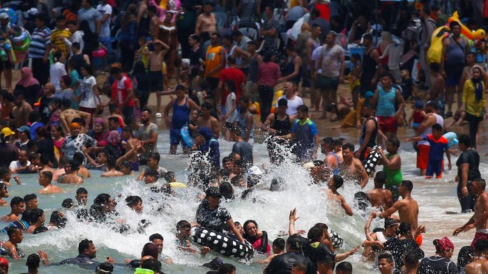 Ribuan Warga Mesir Menyerbu Pantai Saat Dilanda Gelombang Panas Egyptians enjoy themselves at a public beach during a heatwave that coincided with the Muslim Eid al-Adha vacation, in the Mediterranean city of Alexandria, Egypt July 11, 2022. REUTERS/Amr Abdallah Dalsh
