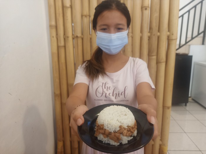 Salah satu pemilik Ruang Makan, Gusti Ayu Krisma (28), menunjukkan menu rice burger di Ruang Makan, Jalan Ahmad Yani No 145 Denpasar, Bali, Rabu (13/7/2022).