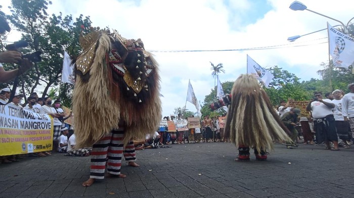 Atraksi budaya berupa tarian barong dan rangda dari Desa Adat Intaran saat melakukan aksi demonstrasi penolakan terminal LNG di kawasan mangrove di depan Kantor Gubernur Bali, Denpasar, Kamis (14/7/2022). 3 Atraksi budaya berupa tarian barong dan rangda dari Desa Adat Intaran saat melakukan aksi demonstrasi penolakan terminal LNG di kawasan mangrove di depan Kantor Gubernur Bali, Denpasar, Kamis (14/7/2022).