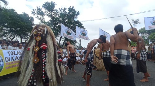 Atraksi budaya berupa tarian barong dan rangda dari Desa Adat Intaran saat melakukan aksi demonstrasi penolakan terminal LNG di kawasan mangrove di depan Kantor Gubernur Bali, Denpasar, Kamis (14/7/2022).