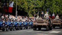 Presiden Prancis Emmanuel Macron memimpin parade militer di atas mobil komando.