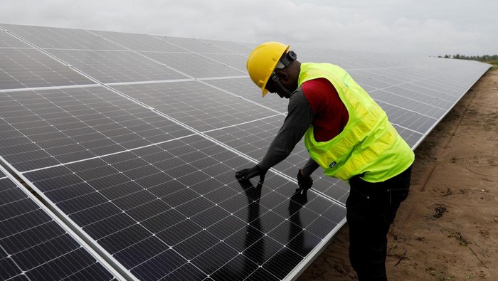 BBM Solar Mahal, Permintaan Tenaga Surya di Nigeria Melonjak Solar power technicians walk past the fishing pond at the Atlantic Shrimpers farm in Badagry, Lagos, Nigeria July 5, 2022. REUTERS/Temilade Adelaja