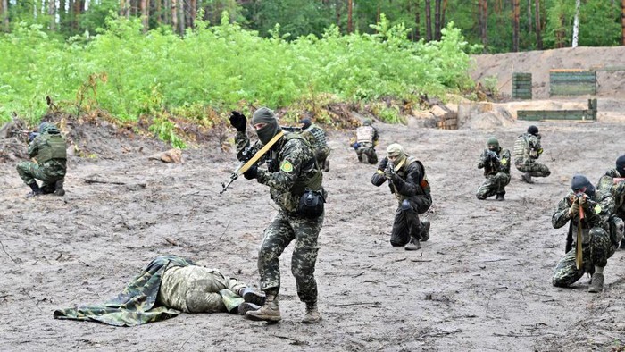Begini Latihan Tempur Pasukan Ukraina di Bucha Fighters of the territorial defence unit, a support force to the regular Ukrainian army, take part in an exercise as part of the regular combat tactics classes, not far from the Ukrainian town of Bucha, Kyiv region on July 13, 2022 amid the Russian invasion of the country. (Photo by Sergei SUPINSKY / AFP) (Photo by SERGEI SUPINSKY/AFP via Getty Images)