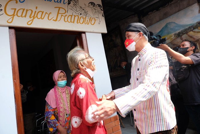 GUBERNUR JATENG KUNJUNGI RUMAH MAESTRO WAYANG BEBER Gubernur Jawa Tengah Ganjar Pranowo mengamati hasil karya maestro lukis Wayang Beber Hermin Istiariningsih saat mengunjungi kediamannya di Kampung Wonosaren, Jagalan, Solo, Jawa Tengah, Kamis (14/7/2022). Kunjungan tersebut untuk meninjau bantuan Rumah Tidak Layak Huni (RTLH) sehingga memenuhi kebutuhan rumah tinggal yang layak huni bagi keluarga Hermin Istiariningsih. ANTARAFOTO/Maulana Surya/hp.