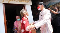 Gubernur Jawa Tengah Ganjar Pranowo (kanan) menemui maestro lukis Wayang Beber, Hermin Istiariningsih (kiri) dan suaminya Sutrisno (tengah) di Kampung Wonosaren, Jagalan, Solo, Jawa Tengah, Kamis (14/7/2022).