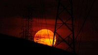 Bulan purnama yang dikenal sebagai Buck Moon terbit di atas Ciudad Juarez, Meksiko, Rabu, (13/7/2022). Fenomena ini terakhir terjadi pada tahun 2004 dan 2013. REUTERS/Jose Luis Gonzalez