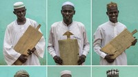 Sejumlah anak muda di Sudan menunjukkan papan kayu yang bertuliskan ayat-ayat Al-Quran di Khartoum, Ibu Kota Sudan, Minggu (10/7/2022).