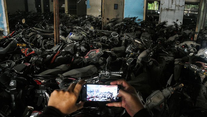 Melihat 'Kuburan' Motor Sitaan di Cikarang Petugas Kepolisian menunjukkan sepeda motor terbengkalai di kantor Laka Lantas Polres Metro Bekasi, Cikarang, Kabupaten Bekasi, Jawa Barat, Kamis (14/7/2022). Sebanyak ribuan motor bekas kecelakaan, sitaan dan hasil tindak kejahatan dari tahun 2004 berada di penampungan ini dan belum diambil pemiliknya. ANTARA FOTO/ Fakhri Hermansyah